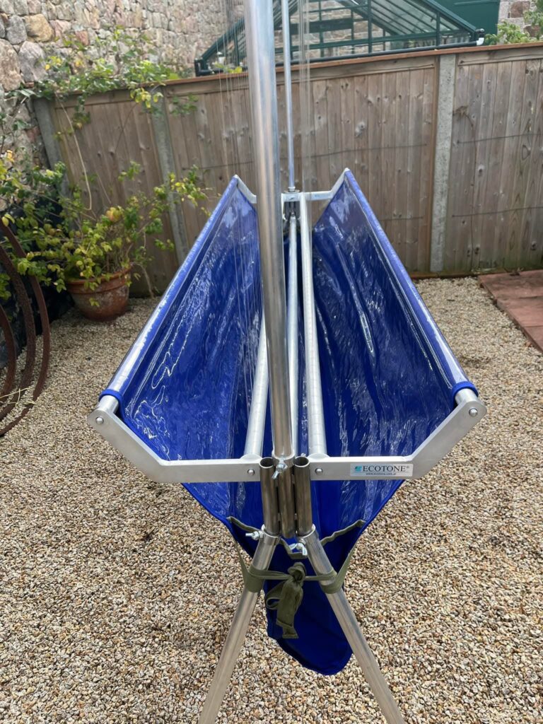 Folded blue tarp on metal stand outdoors.