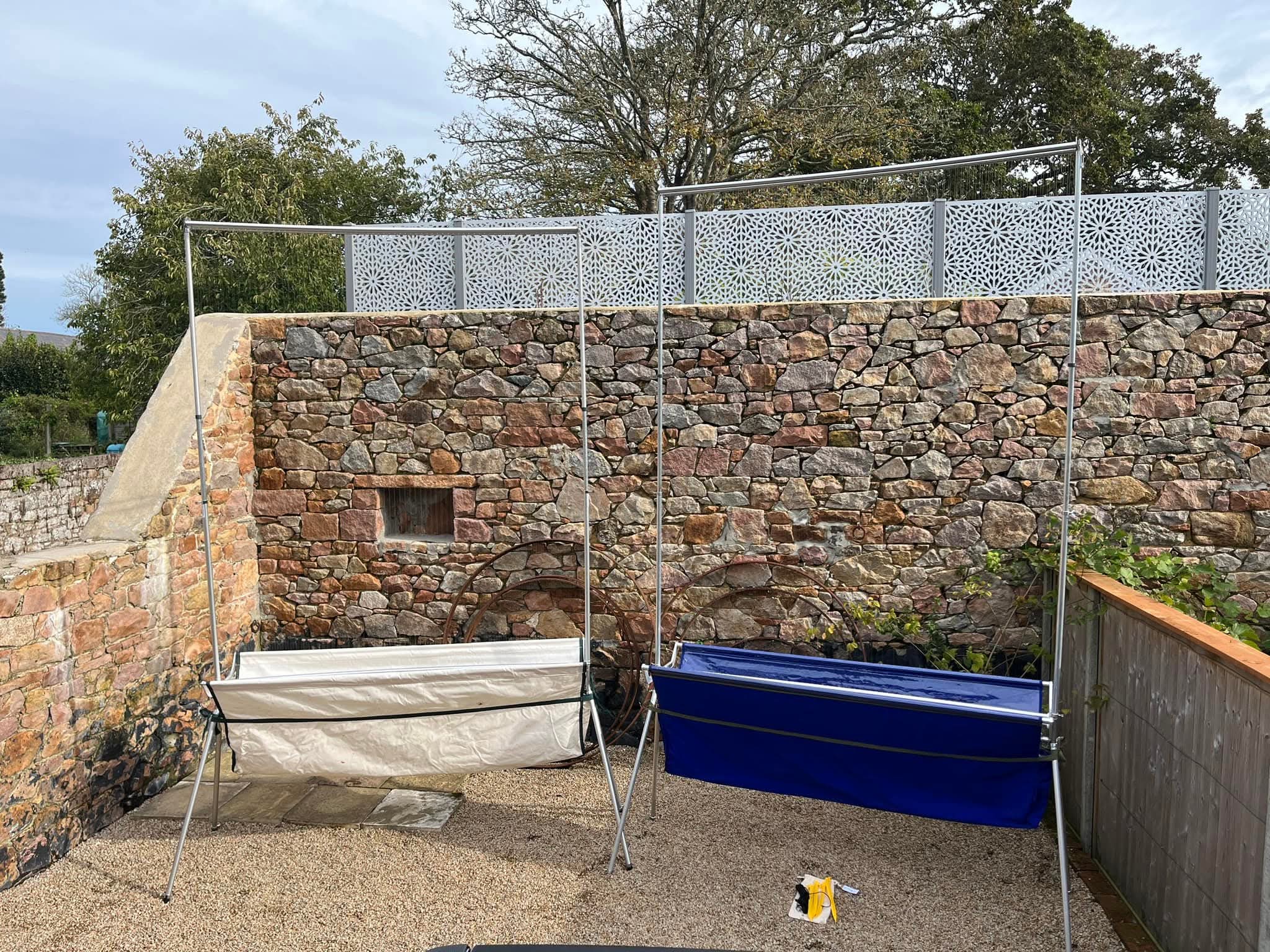 Outdoor clothesline setup against stone wall.