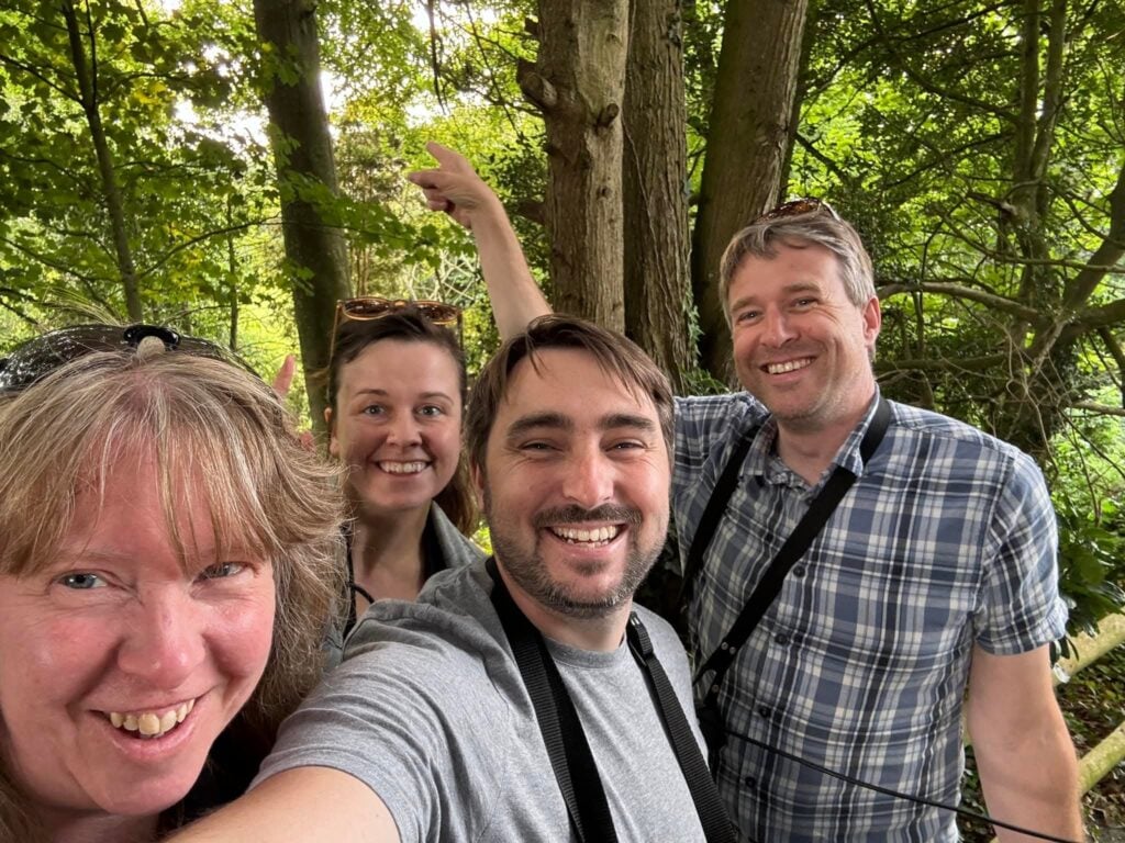 Smiling group of four in forest setting.