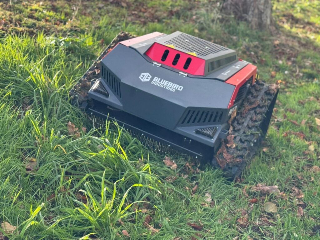 Automated robot mower cutting grass outdoors.