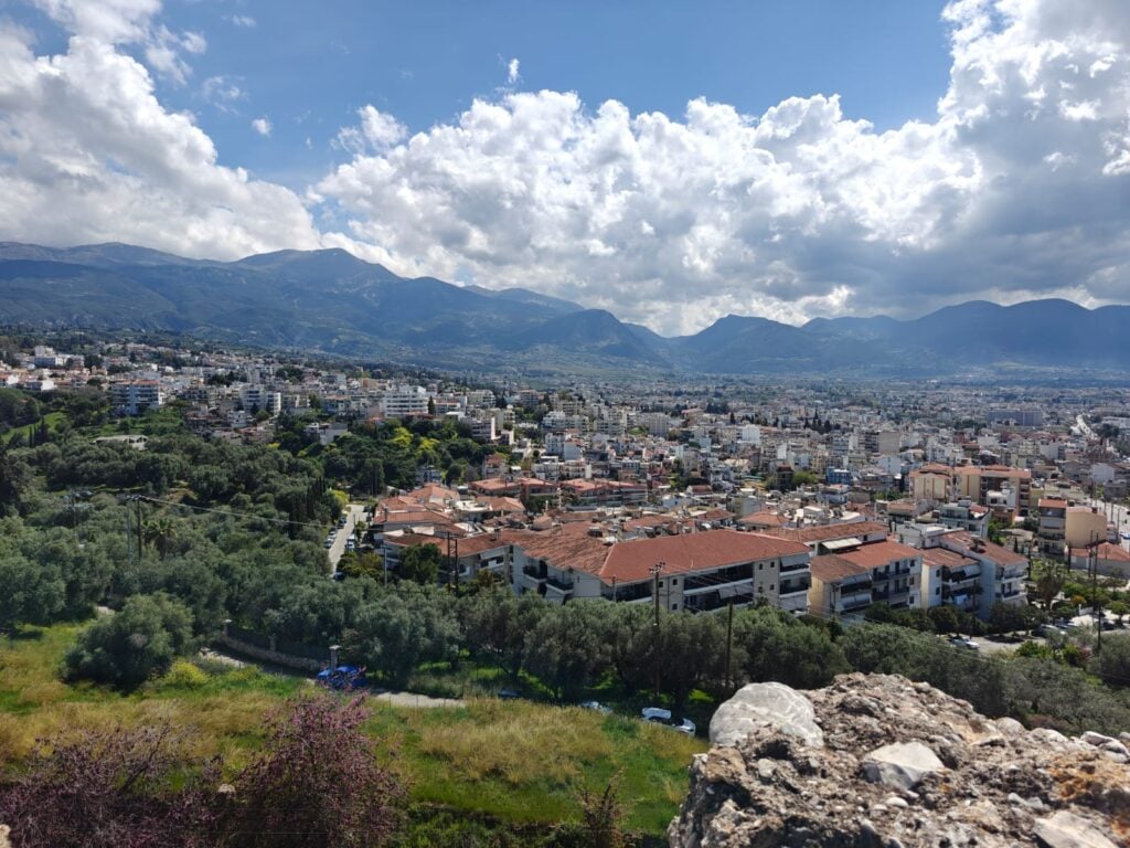Cityscape with mountains and cloudy sky background.