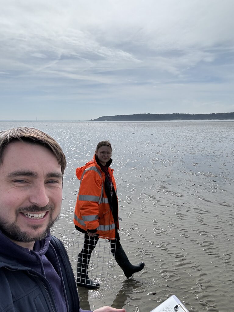 Two people on beach with safety gear.