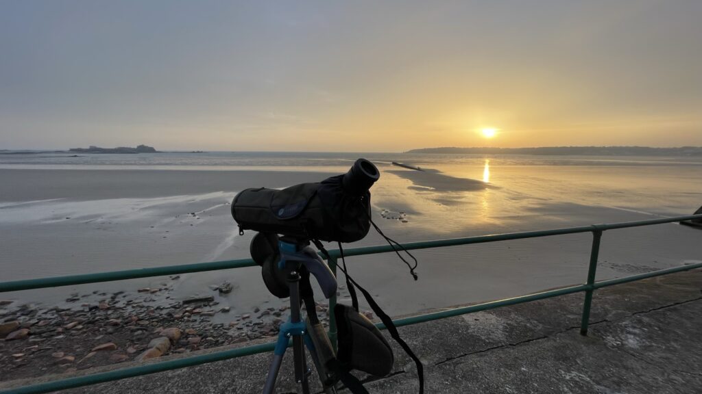 Telescope on beach at sunrise