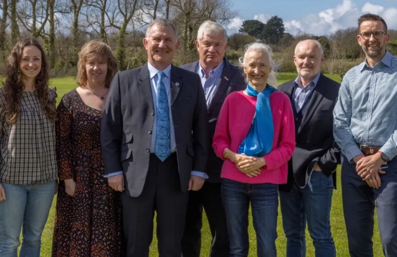 Group of people standing outdoors in a field.